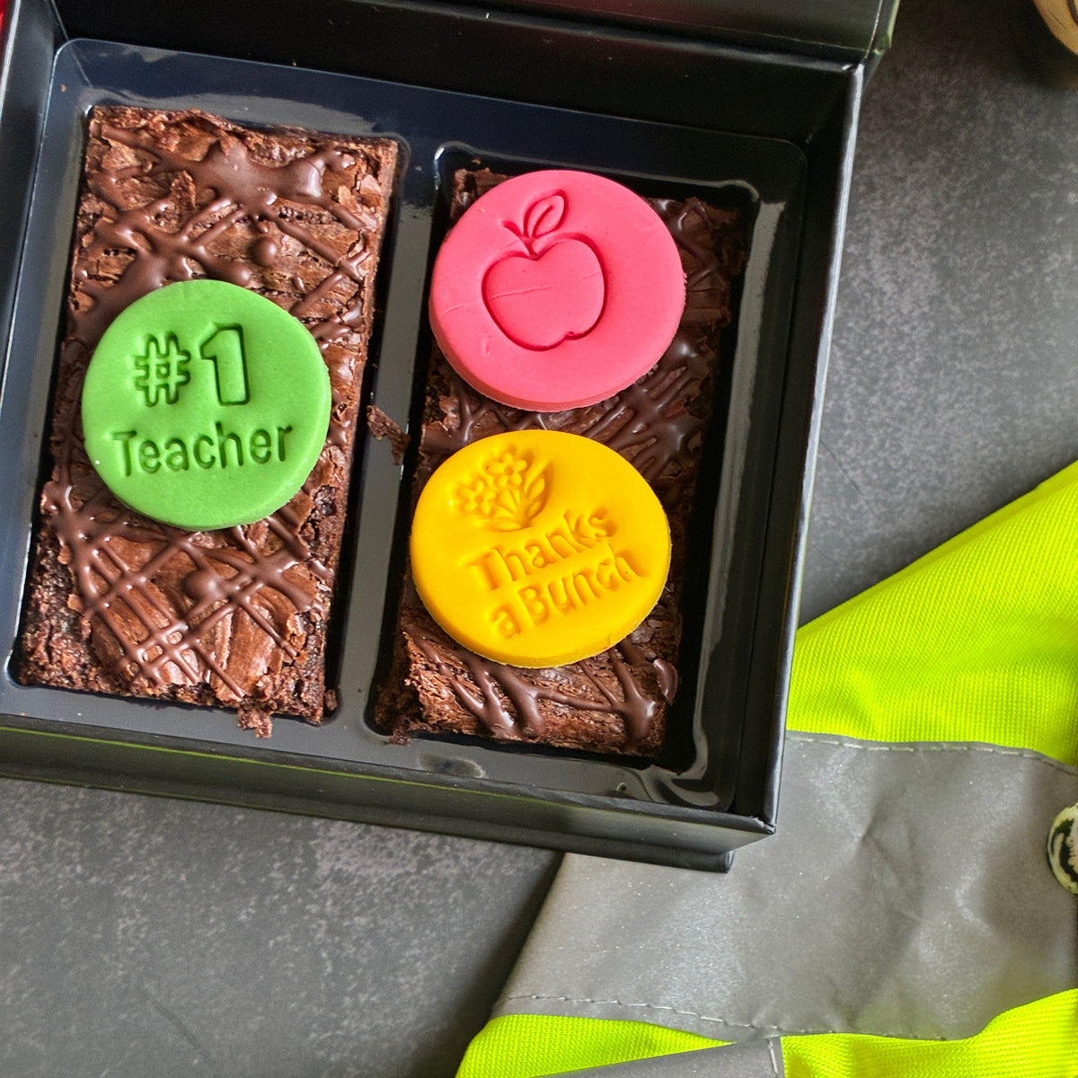 A closeup of two bars of fudgy chocolate brownies, decorated witrh edible messages perfect for gifting to educators and teachers alike!