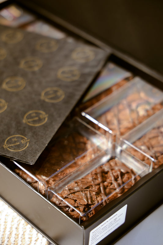 Close-up of Signature Death By Chocolate brownies in a premium branded black and gold gift box.